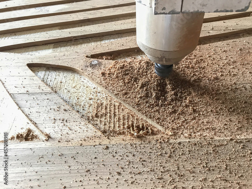 Φωτογραφία CNC laser machine working process on wooden door for making grooves by computer control
