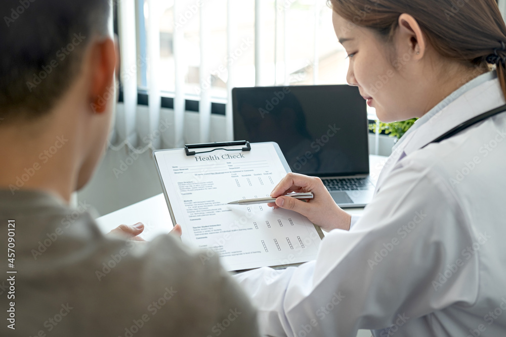 Doctor is pointing on document to explaining disease and symptoms for patient during to talking Doctor is pointing on document to explaining disease and symptoms for patient during to talking