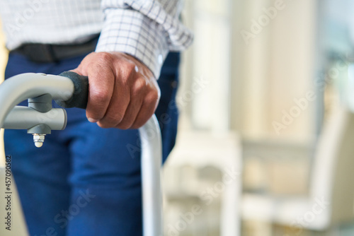 The hand of a senior leans on a rollator