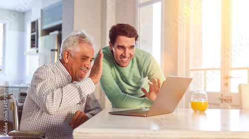 Senior and son video chat on computer with family