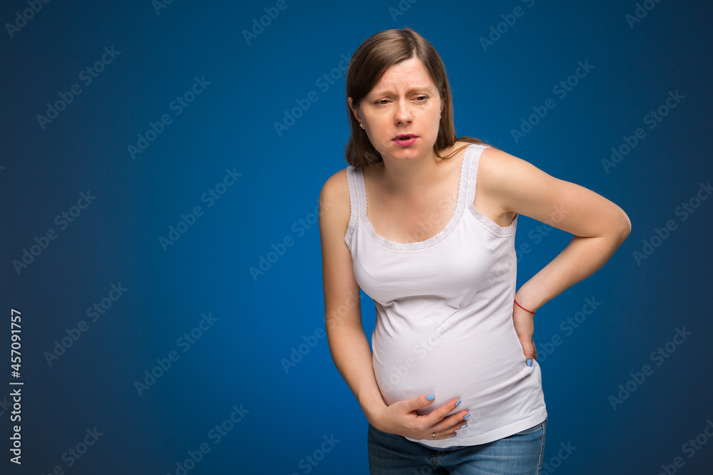 Pregnant woman feeling pain in the back and in the belly, contractions begin. Sickness in perinatal time. Pregnant woman feeling pain in the back and in the belly, contractions begin. Sickness in perinatal time.