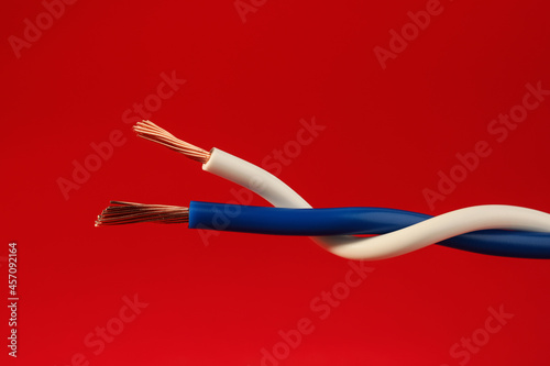 Two different electrical wires on red background, closeup © New Africa