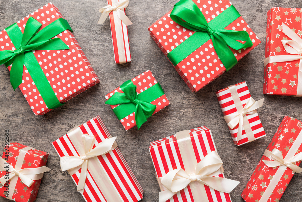 Fototapeta premium A lot of Christmas gift boxes in colored paper decorated on table, Top view close up. Many present New Year gift