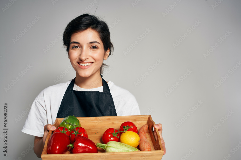 cheerful Woman in a black apron vegetables housework cooking cheerful Woman in a black apron vegetables housework cooking