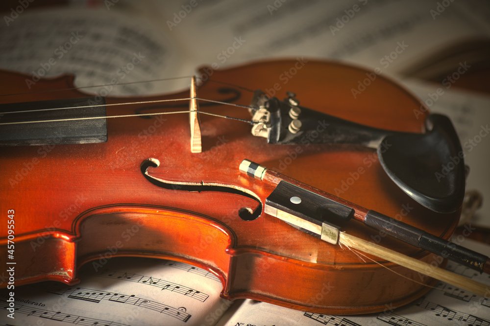 Naklejka premium Violin and bow resting on sheet music
