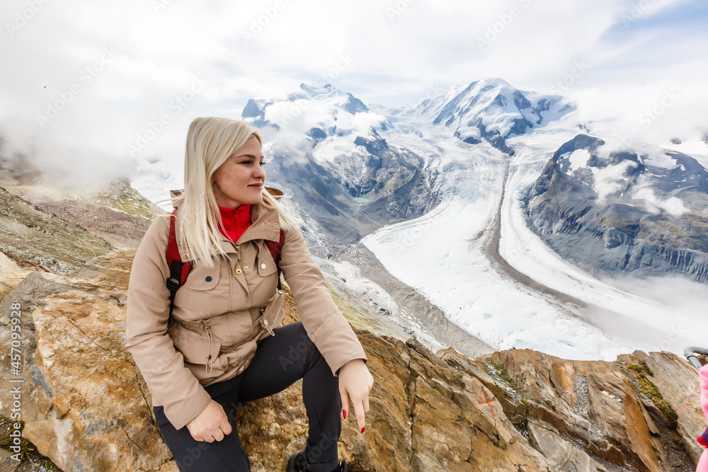 Rear view of a woman with backpack looking at the view Female hiker relaxing on mountain top.