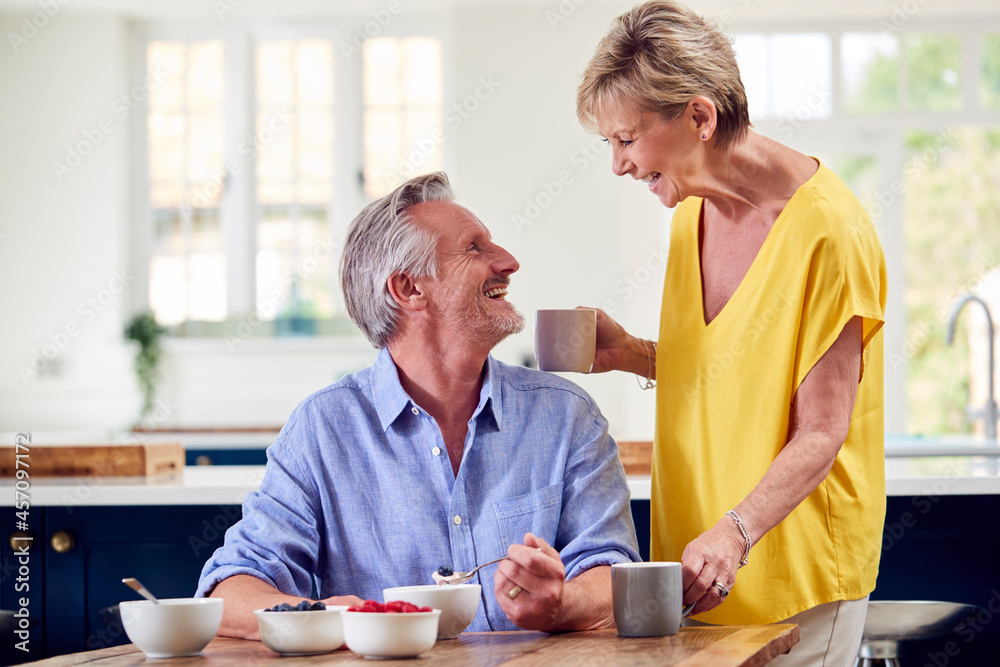 Retired Couple Sitting Around Table At Home Having Healthy Breakfast Together Retired Couple Sitting Around Table At Home Having Healthy Breakfast Together