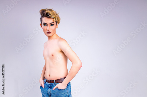 Tableau sur toile blond man with make up on face posing in studio on white background