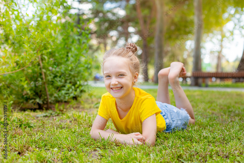 a little girl is lying on the lawn resting in the park a little girl is lying on the lawn resting in the park
