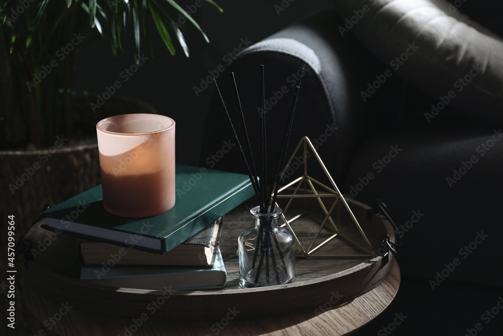Wooden tray with decorations and books on table in room Wooden tray with decorations and books on table in room