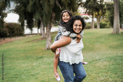 Happy indian mother having fun with her daughter outdoor - Focus on mother face