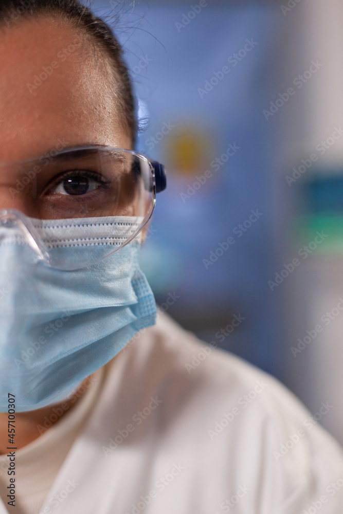 Close up of scientist woman with glasses and face mask in medical laboratory at clinic. Professional analysis doctor with safety equipment and microbiology devices for research Close up of scientist woman with glasses and face mask in medical laboratory at clinic. Professional analysis doctor with safety equipment and microbiology devices for research