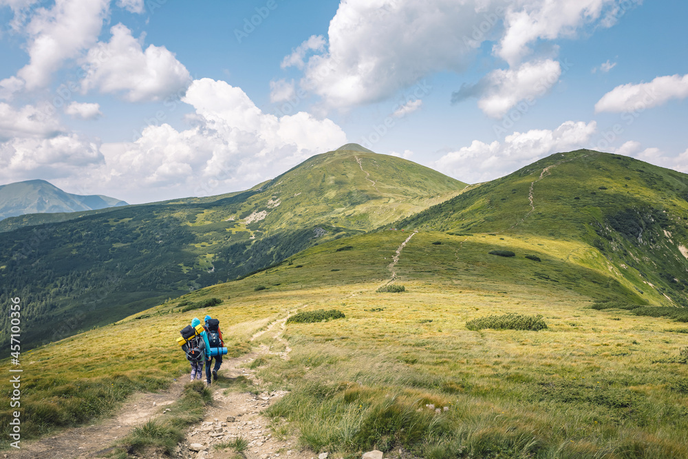 mountain tourism concept. hiking in the mountains. two-wheelers with a backpack on their shoulders traveling the mountain slopes. summer vacation