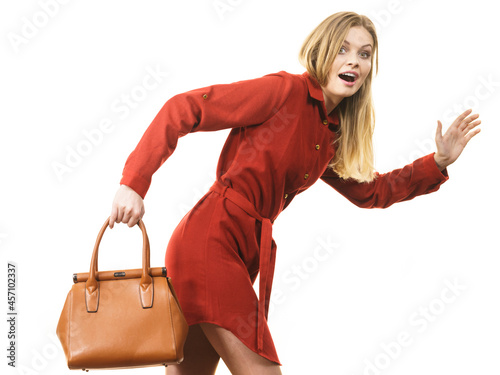 Female wearing red dress holding bag running