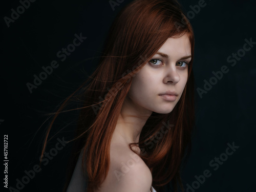 woman with bare shoulders glamor clear skin dark background