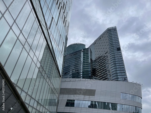 Facade of modern skyscraper with glass walls. From below of contemporary tall skyscraper with glass walls against cloudy sky in downtown