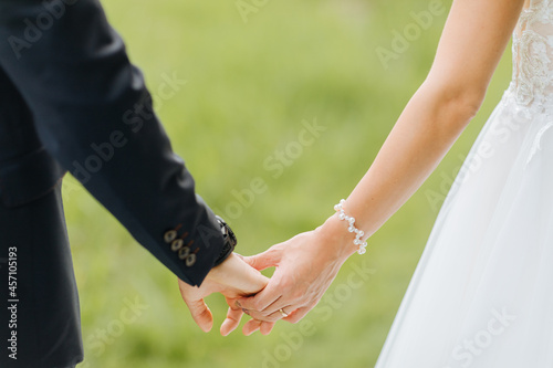 Bride and groom hold hands. Free wedding ceremony in summer. love 