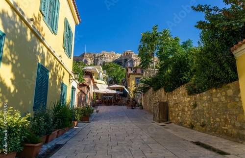 Athens street with yellow house  with the acropolis at the end above the mount