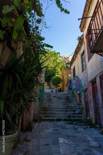 Street in Athens with graffiti and lots of greenery, with stairs up