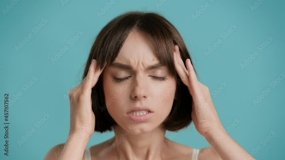 Woman Having Painful Headache Suffering Massaging Temples, Blue Background