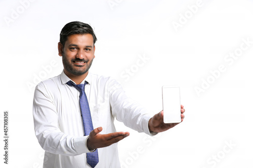 Young indian officer showing smartphone screen on white background.