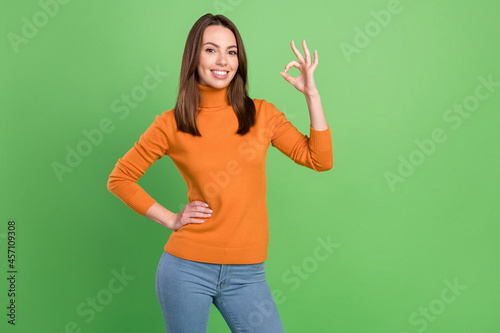 Portrait of attractive cheerful girl showing ok-sign ad advert cool decision isolated over green color background