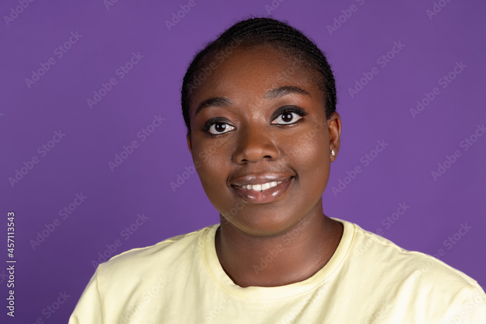 Half-length portrait of African pretty woman isolated on purple, lilac color studio background. Concept of human emotions, facial expression, natural beauty, bodypositive Half-length portrait of African pretty woman isolated on purple, lilac color studio background. Concept of human emotions, facial expression, natural beauty, bodypositive