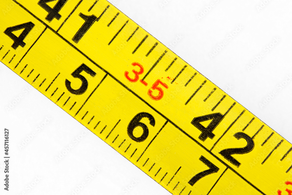 Old measuring tape measure scale in millimeters and inches, macro close-up Old measuring tape measure scale in millimeters and inches, macro close-up