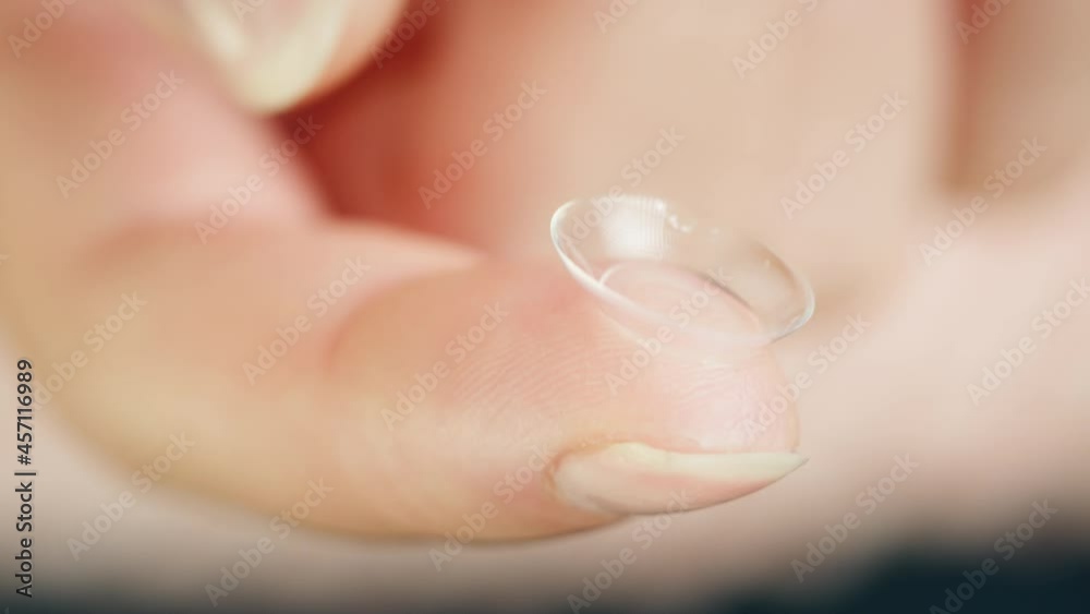 Close-up of a transparent eye lens on finger, decorative lenses. Optical shop concept. Advertising of contact daily lenses for make-up and performances, halloween. 
