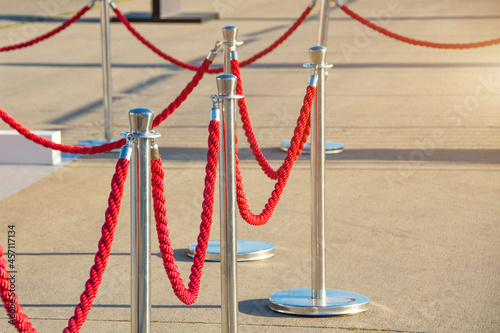 Portable fencing barrier outside. Red carpet safety rope.
