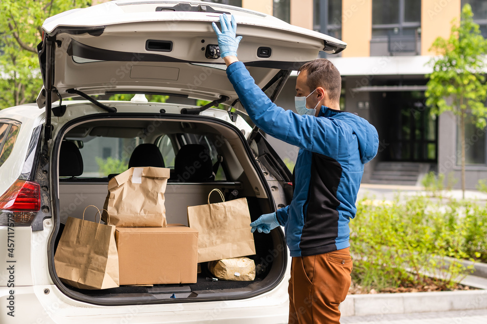 delivery man in a medical mask and gloves delivers the parcel. Quarantine, coronavirus, isolation delivery man in a medical mask and gloves delivers the parcel. Quarantine, coronavirus, isolation