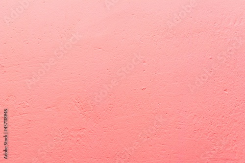 Old pink wall in spots, cracks, stains. Painted concrete wall in abstract grunge style loft. Vintage wall background texture for backgrounds, portraits, posters.