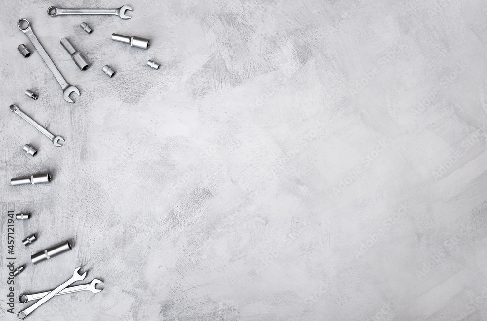 Fototapeta premium Construction background of gray color with hand tools for repair located on it, top view. Equipment on concrete floor, copy space.