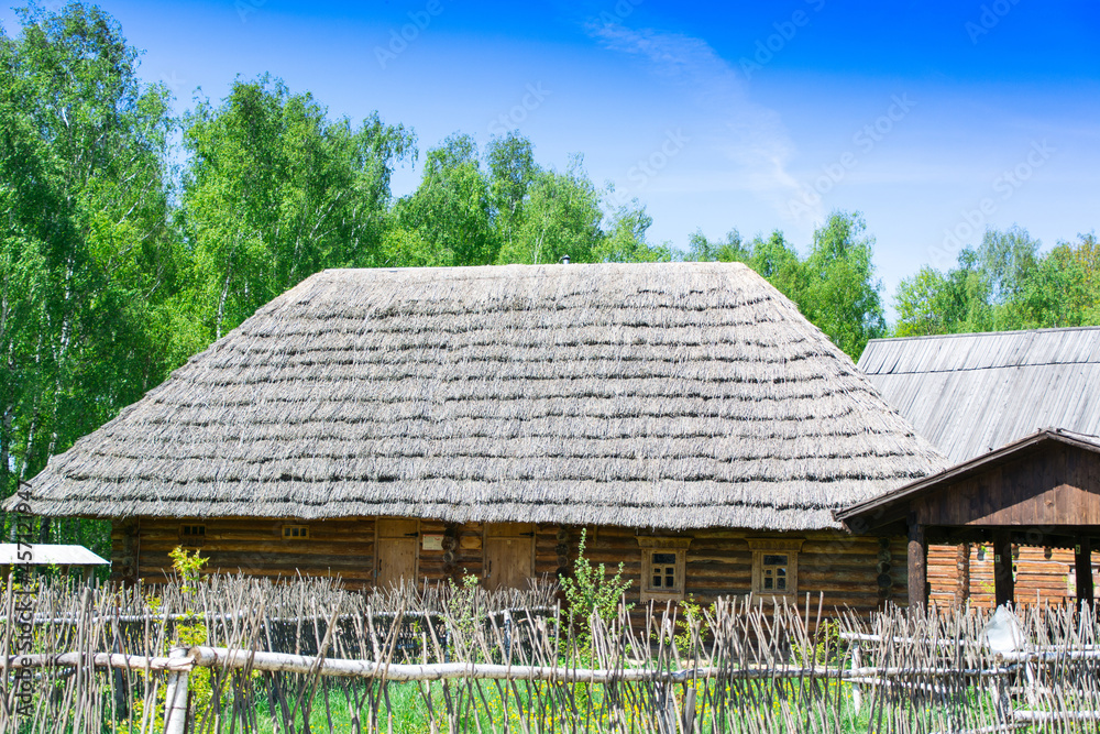 Obraz premium Etnomir, Russia. March 12, 2018. A street of wooden houses with a thatched roof