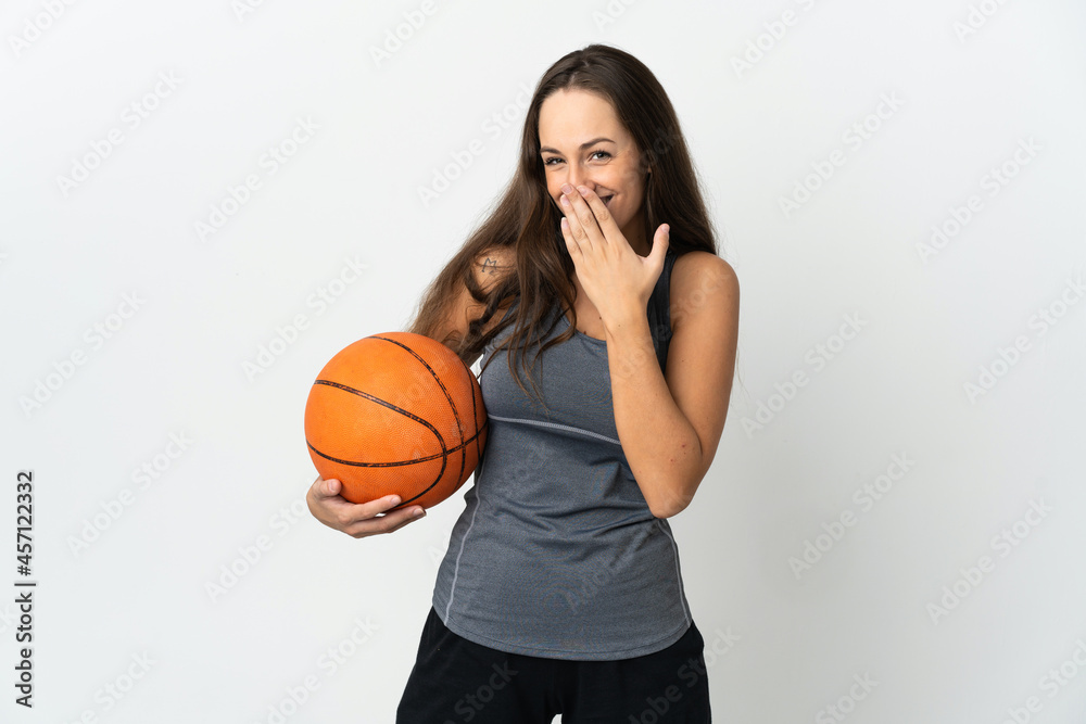 Young woman playing basketball over isolated white background happy and smiling covering mouth with hand