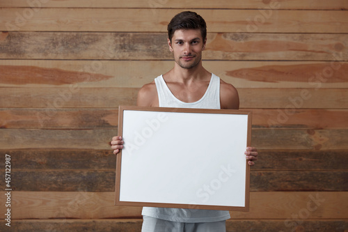 Fotografie Young smiling european man hold empty white frame