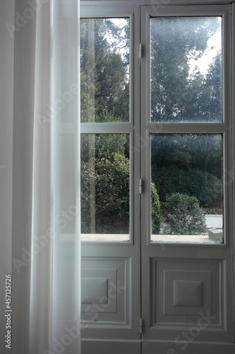  interior italian style: calm room, exit from house to the garden, white wooden doors with glass, classic cozy curtains