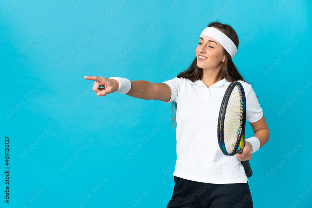 Young hispanic woman over isolated blue background playing tennis