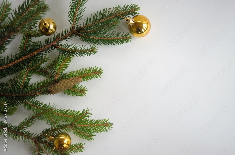 Branches of the Christmas tree with gold balls on a white background with a place for recording New Year's greetings, flat layout Branches of the Christmas tree with gold balls on a white background with a place for recording New Year's greetings, flat layout