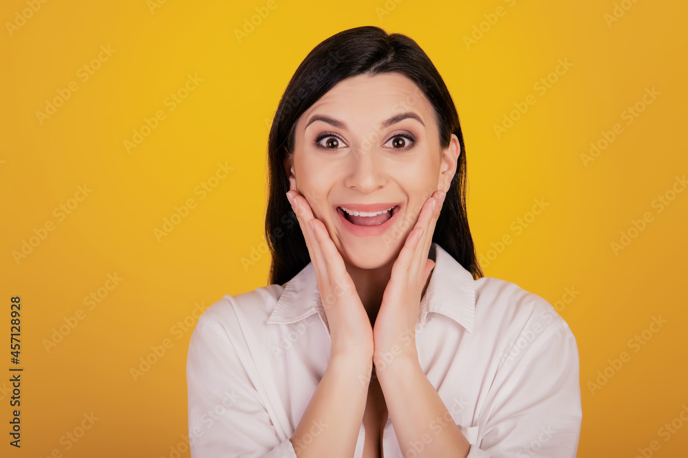 Portrait of amazed positive girl hands cheeks on yellow background Portrait of amazed positive girl hands cheeks on yellow background