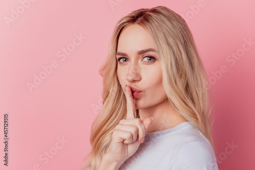 Portrait of charming gorgeous lady finger cover lips on pink background