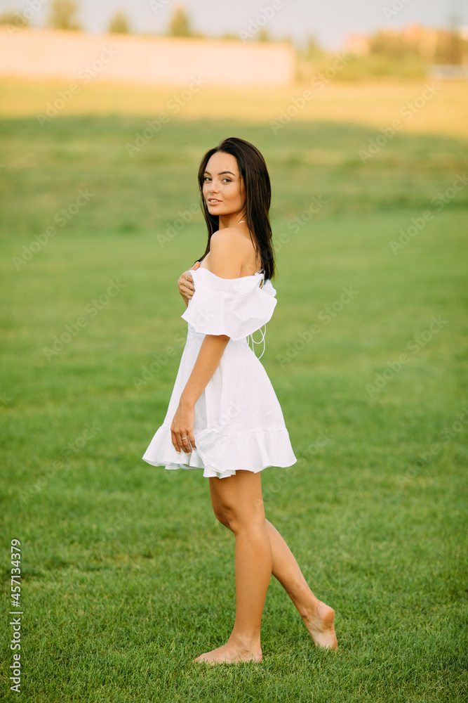 Young woman walks barefoot in meadow on sunny day. Young woman walks barefoot in meadow on sunny day.