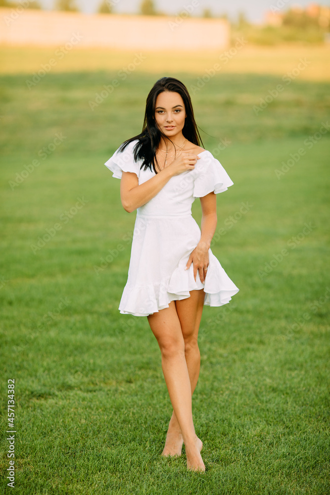 Young woman walks barefoot in meadow on sunny day. Young woman walks barefoot in meadow on sunny day.