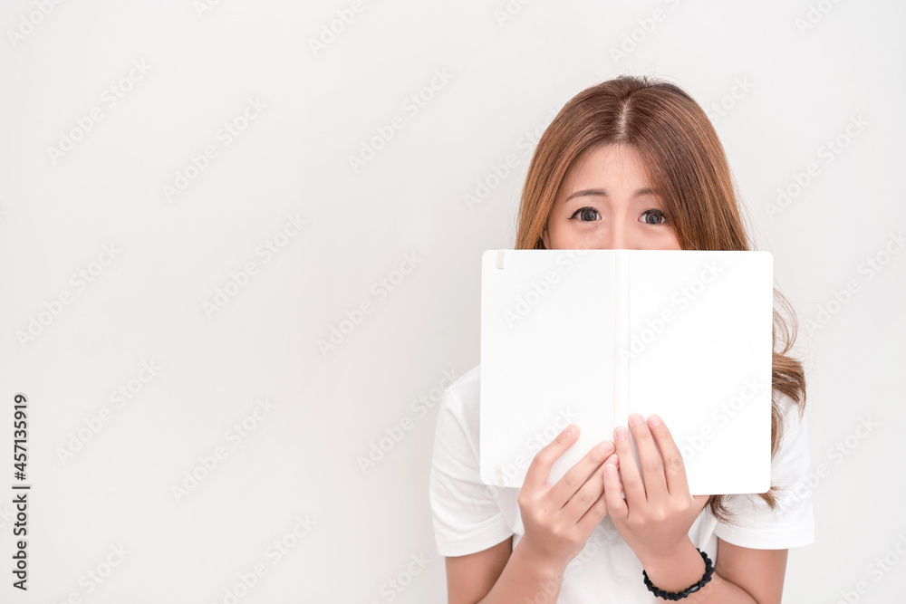 Young attractive asian student holding books in her arm on white background. School girl with a books to read for homework. Young attractive asian student holding books in her arm on white background. School girl with a books to read for homework.