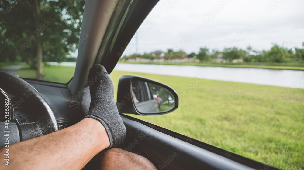 Freedom car travel concept -  Young man relaxing with feet on dashboard. handsome man in the car.