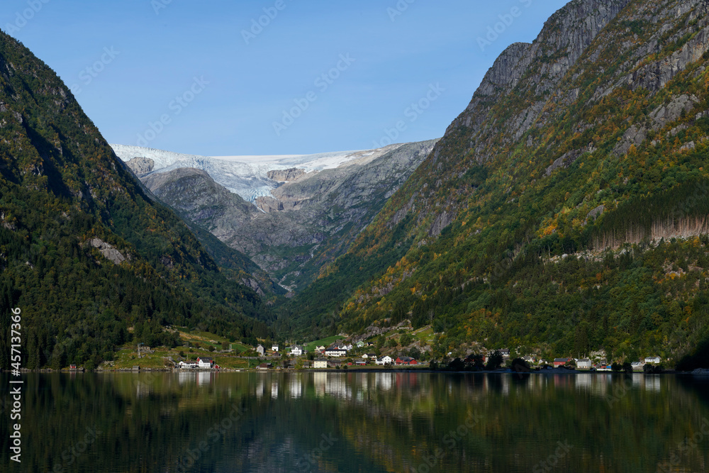 Fototapeta premium Efecto espejo en el fiordo con las montañas noruegas en el fondo