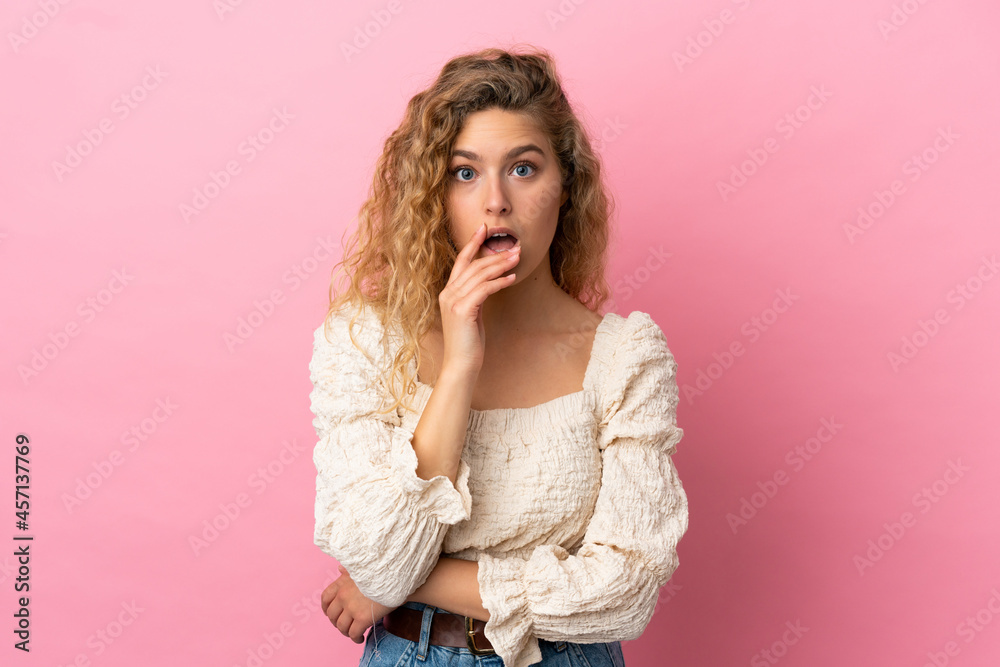 Young blonde woman isolated on pink background surprised and shocked while looking right Young blonde woman isolated on pink background surprised and shocked while looking right