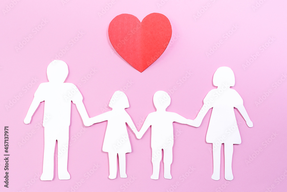 Paper family cut out on bright pink background with paper heart. Family home, foster care, family mental health, divorce and family crisis concept Paper family cut out on bright pink background with paper heart. Family home, foster care, family mental health, divorce and family crisis concept
