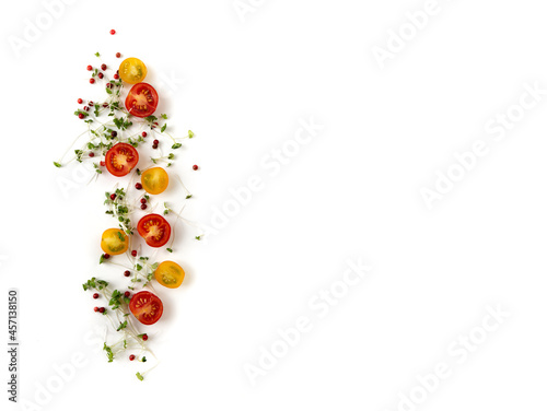 Composition of red and yellow cherry tomatoes with microgreens and pink pepper on a white background  isolated