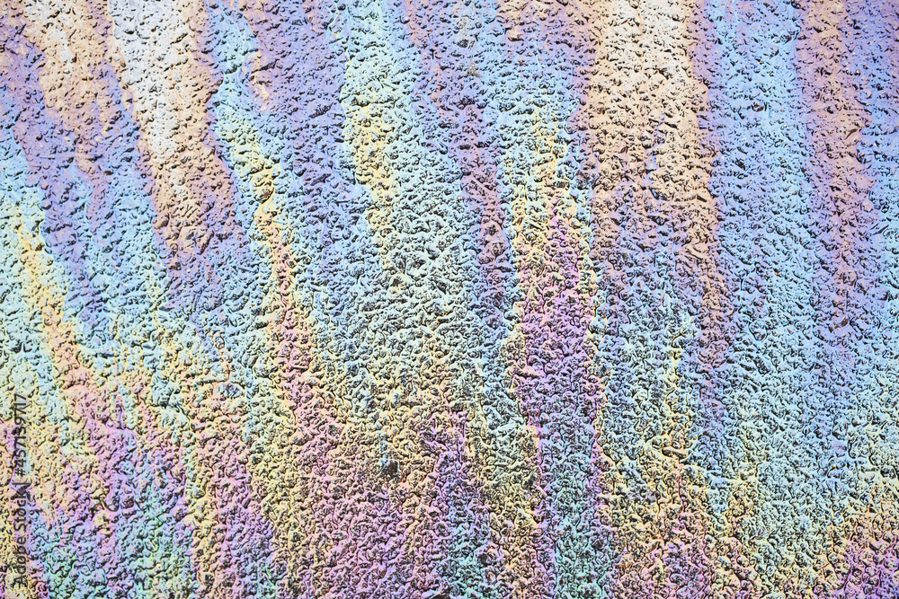 Oil spill pattern on wet asphalt. Abstract colorful background image.